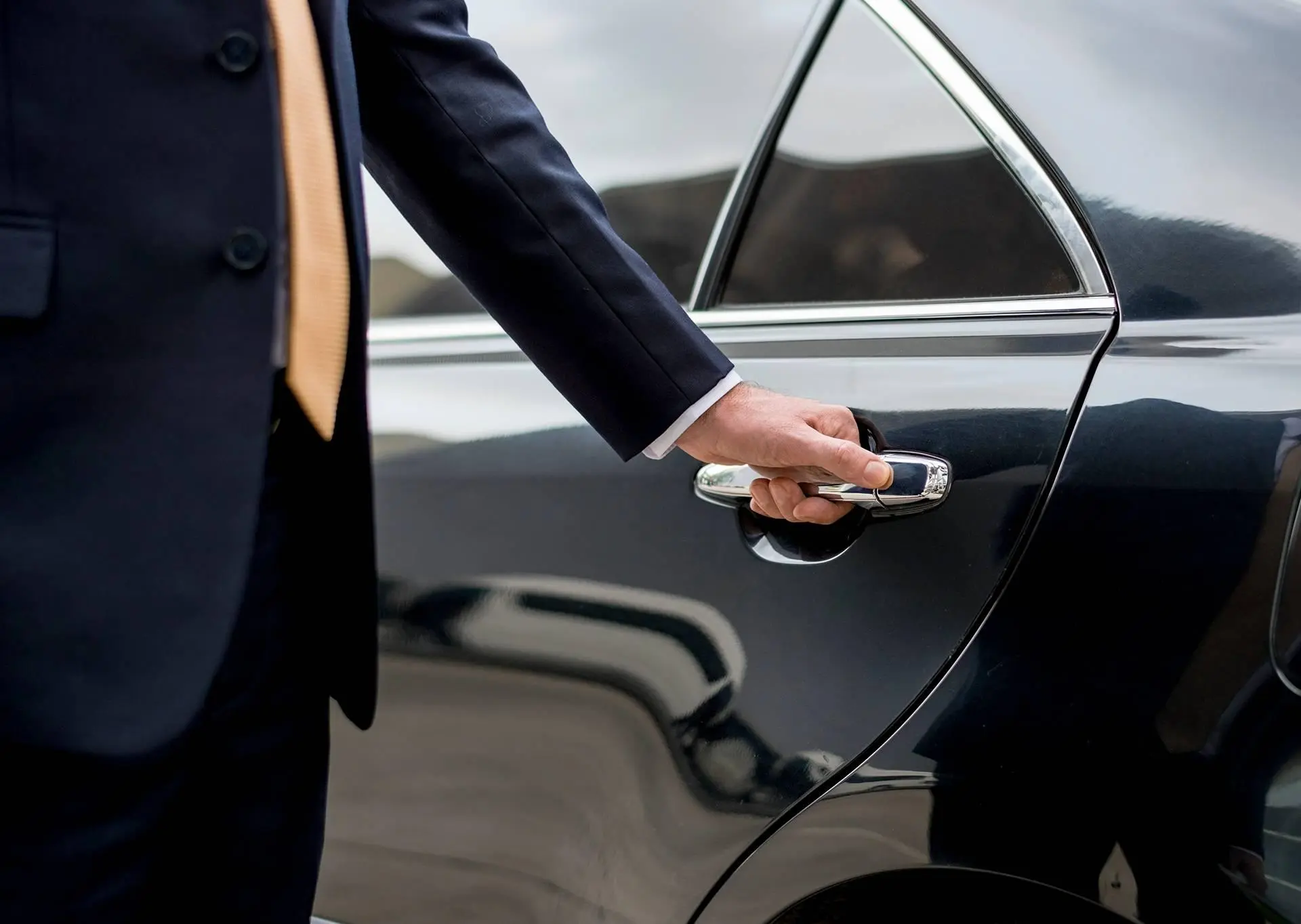 person opening black car door